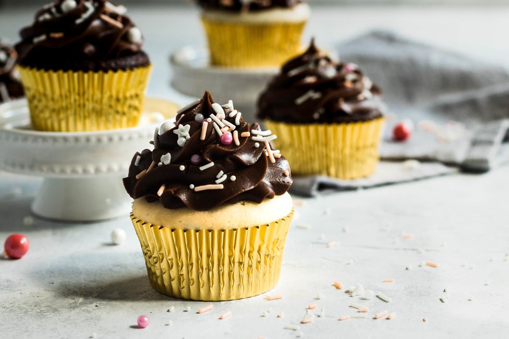 Cupcakes with Chocolate Fudge Frosting swirled on top and finished with colorful sprinkles