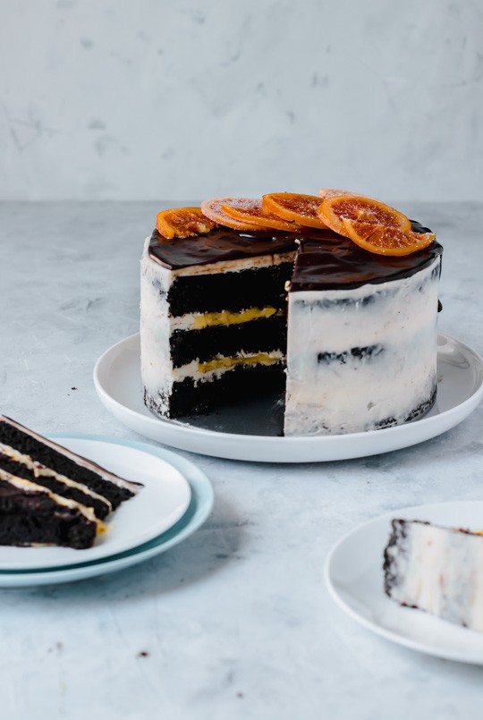 Chocolate Orange Layer Cake -- Three layers of chocolate cake, filled with orange curd and frosted with a light Swiss buttercream. Chocolate ganache and candied oranges are the perfect garnish on top.