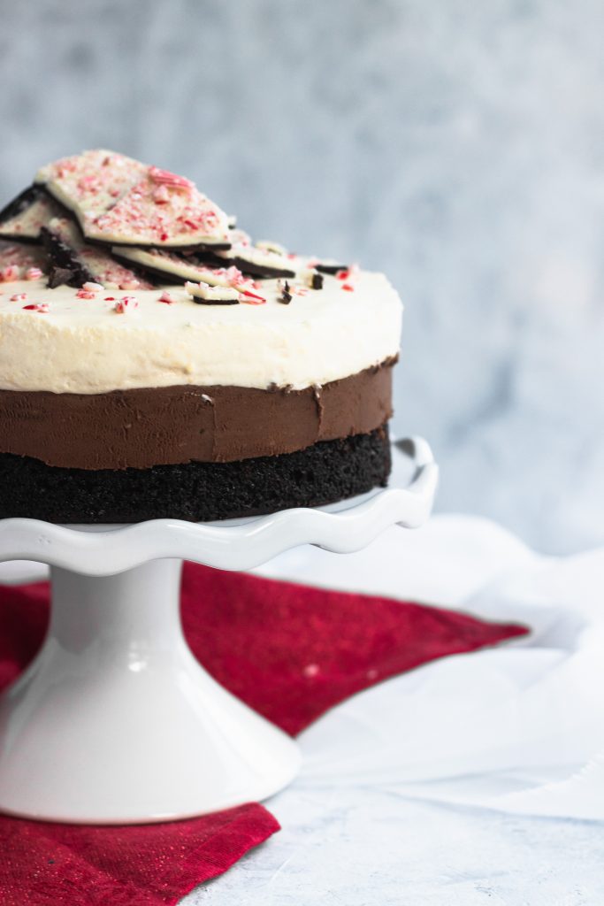 Peppermint Chocolate Mouse Cake -- a dark chocolate sponge topped with a layer of chocolate mousse, then a layer of peppermint mousse, all garnished with chocolate peppermint bark