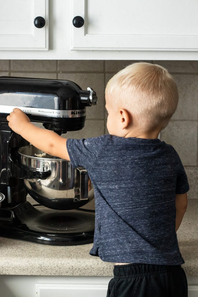 A little boy turning the mixer off--letting kids turn on switches is a great tip for baking with kids!