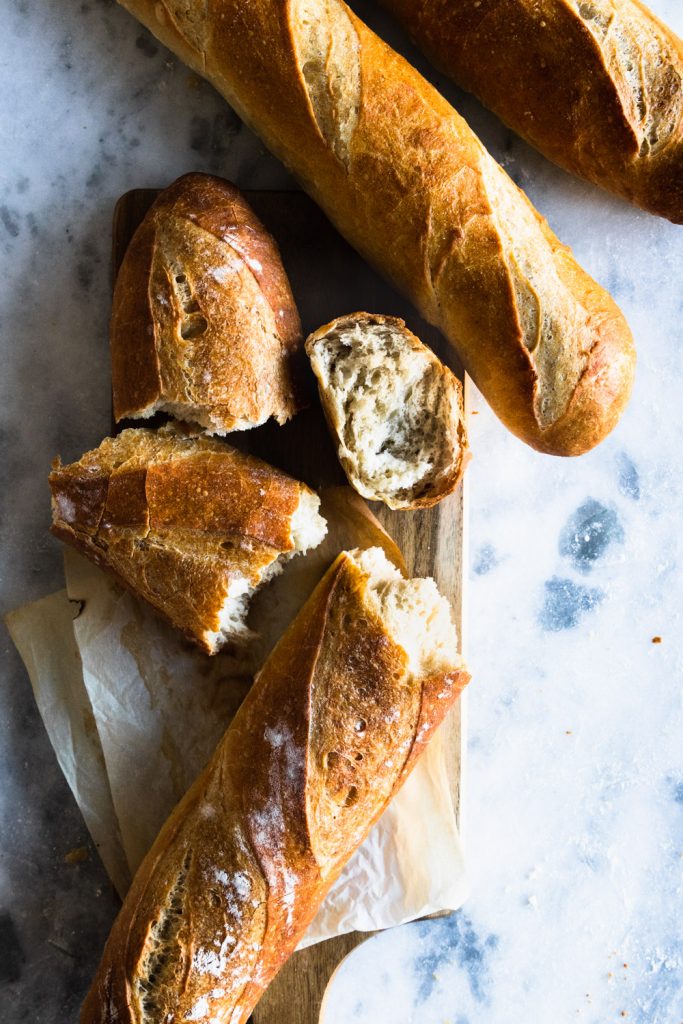 This French baguette recipe will give you crusty, beautiful long loaves. This one is torn open to show the tender, airy crumb inside.