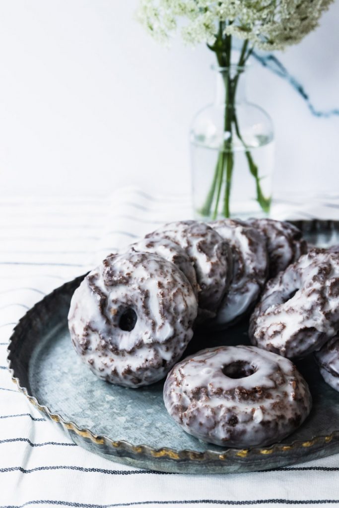 A tray of glazed chocolate old-fashioned donuts