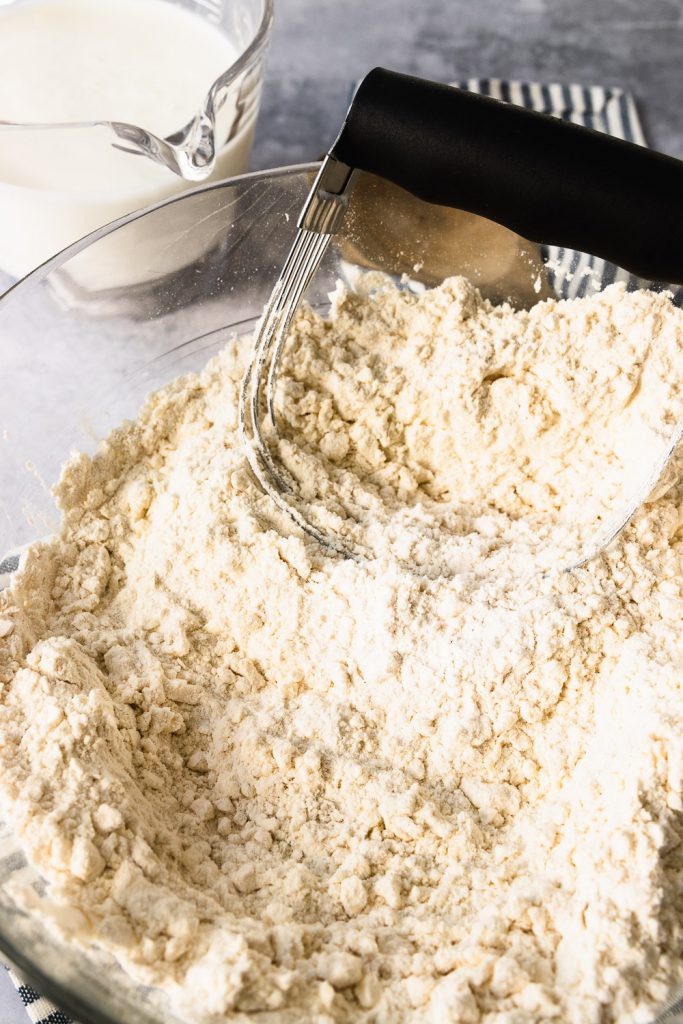 Cut the butter into the flour with a pastry blender or two knives until it's the texture of clumpy sand.