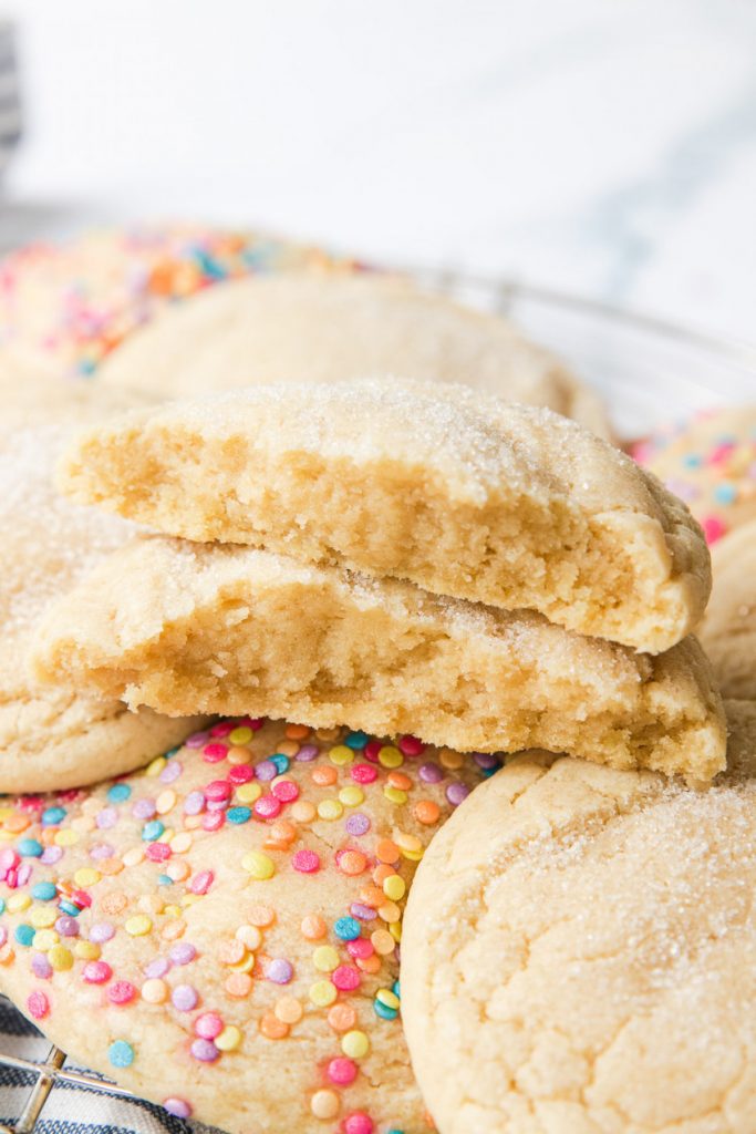 A sugar cookie broken open to show a soft inside with chewy edges.
