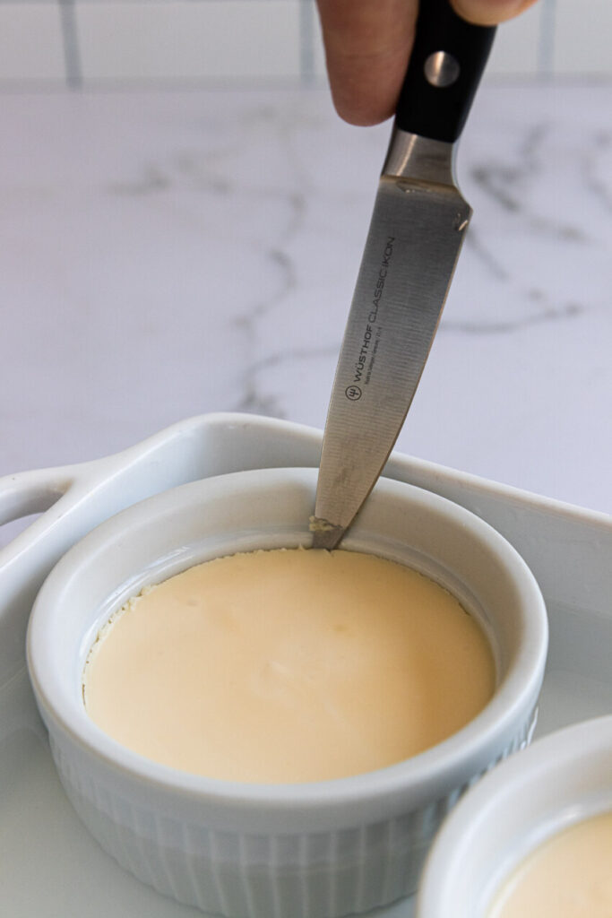 Run the tip of a sharp knife around the edge of each ramekin and place it in hot water for a few seconds to help it release.