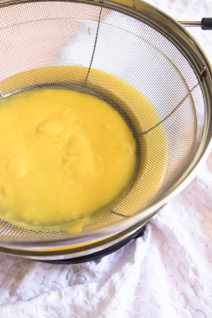 Pour the pastry cream through a sieve placed over a bowl to remove and small bits of cooked egg.