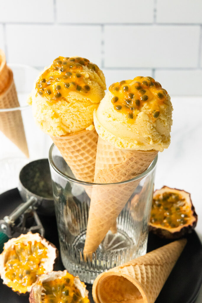 Two scoops of passion fruit ice cream in sugar cones.