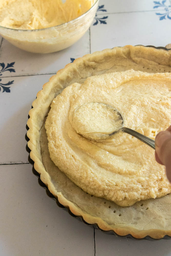 Spreading the frangipane over the bottom of the parbaked tart crust.