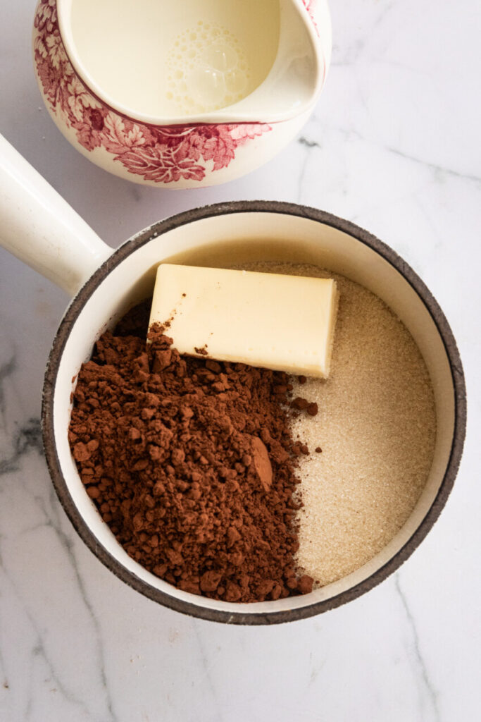 The ingredients for boiled chocolate frosting-- butter, sugar, cocoa powder, and milk.