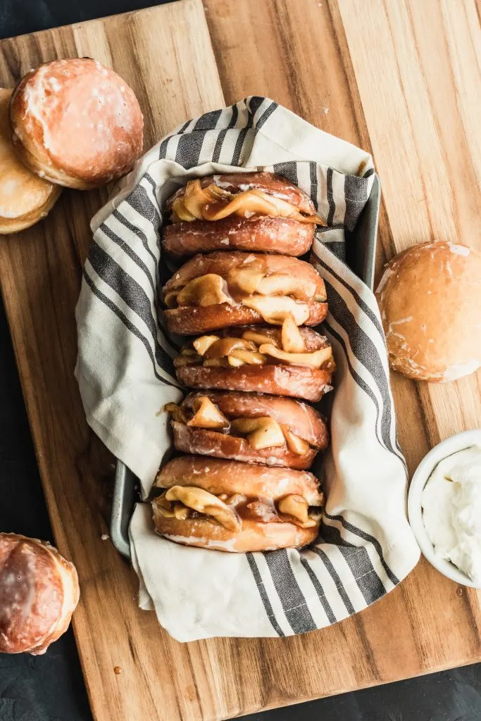 Soft yeast donuts stuffed with spiced apple filling make these Apple Pie Donuts the ultimate fall treat! Serve with whipped cream and an extra dusting of cinnamon. || Good Things Baking Co. #goodthingsbaking #donuts #applepie #fallbaking #doughnuts