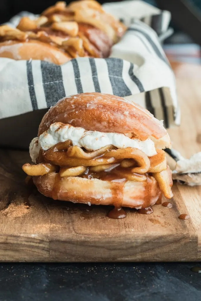 Soft yeast donuts stuffed with spiced apple filling make these Apple Pie Donuts the ultimate fall treat! Serve with whipped cream and an extra dusting of cinnamon. || Good Things Baking Co. #goodthingsbaking #donuts #applepie #fallbaking #doughnuts