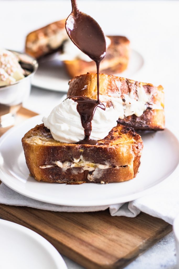Chocolate Drizzling over Whipped Cream Piled on Top of French Toast
