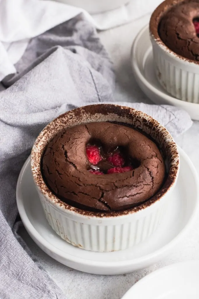 Raspberry Chocolate Lava Cakes with an oozing chocolate and raspberry center, garnished with creme anglaise and fresh raspberries