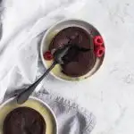 Raspberry Chocolate Lava Cakes with an oozing chocolate and raspberry center, garnished with creme anglaise and fresh raspberries