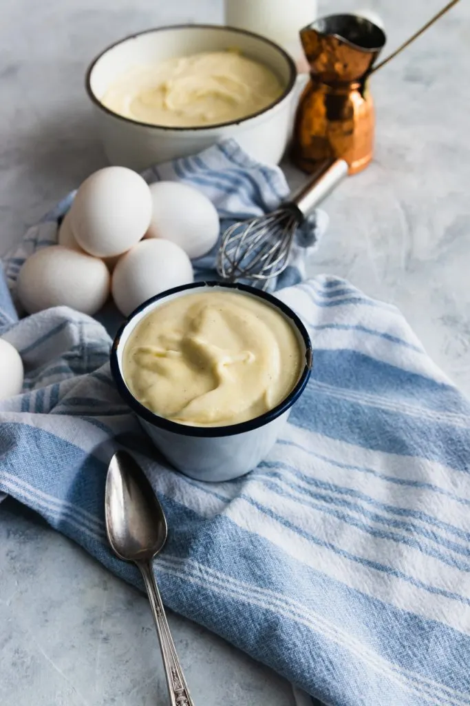 A bowl of classic pastry cream and the ingredients needed to make it.