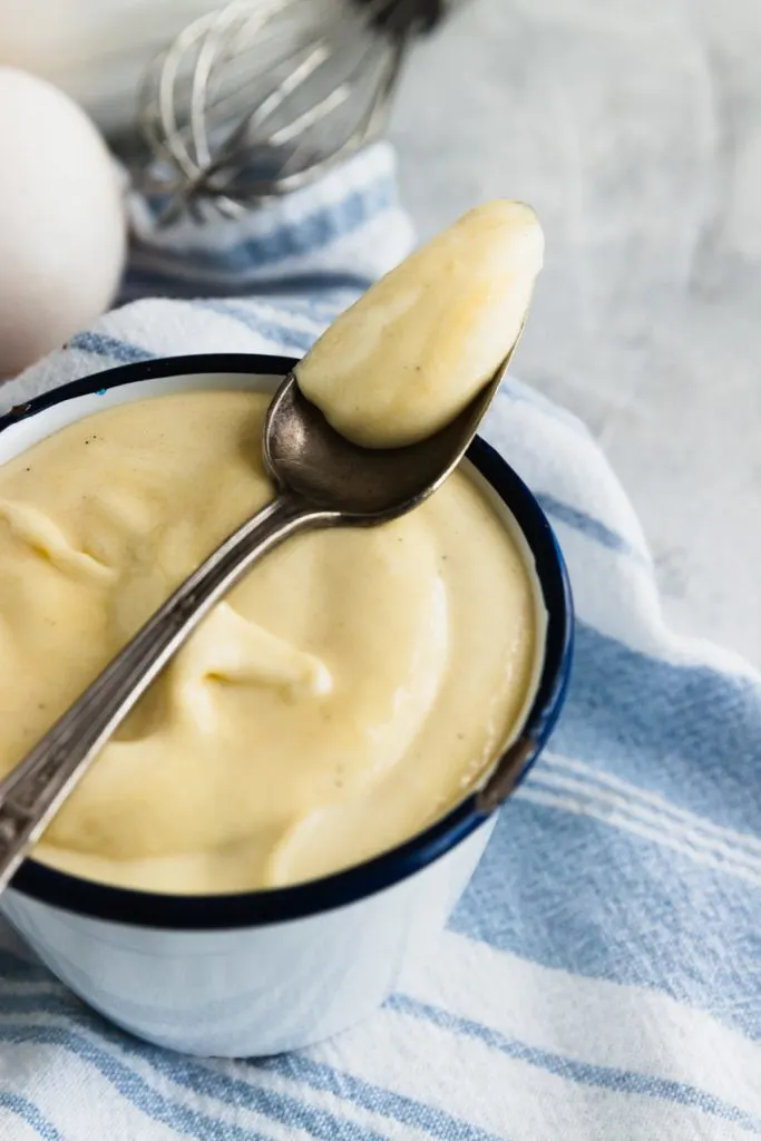 Creamy, thick, classic pastry cream on a spoon.