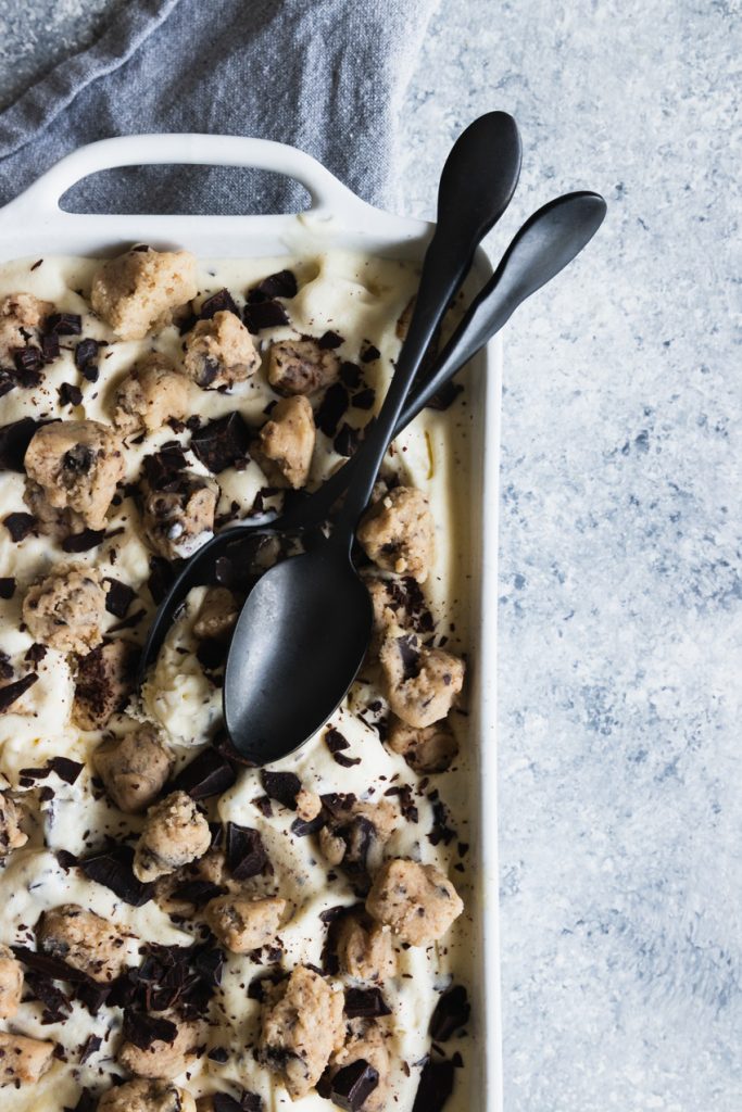 A pan of cookie dough ice cream with two spoons to dig in!
