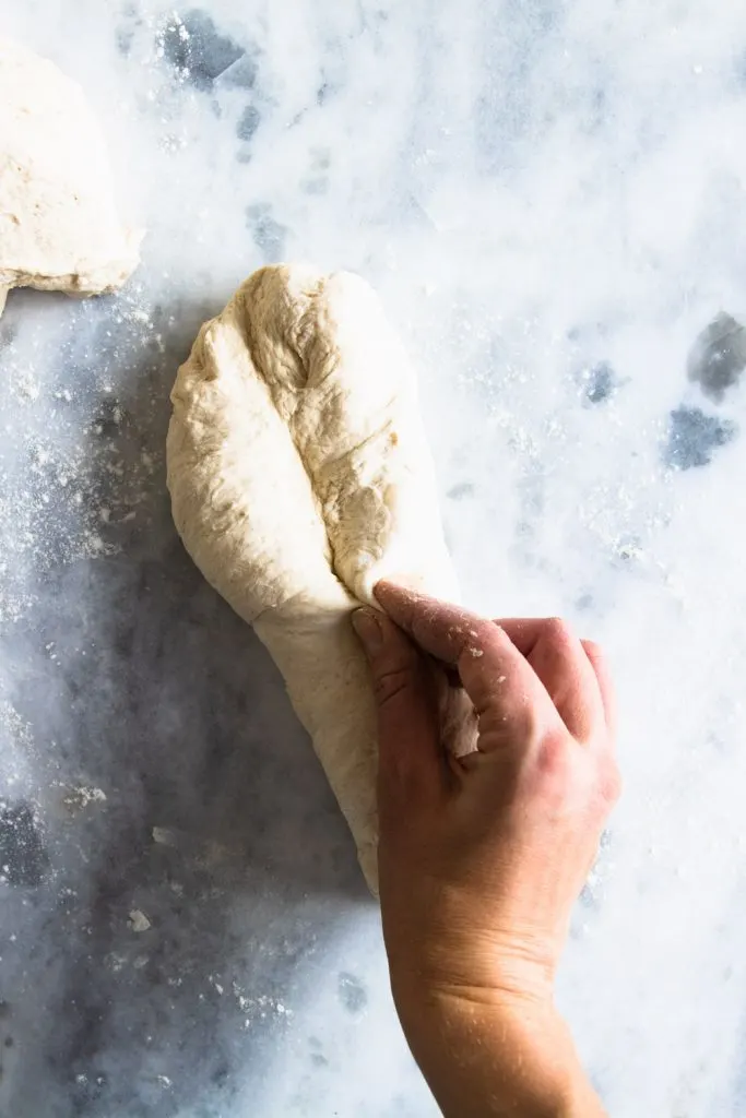 Step four for shaping baguettes: Bring around the edges of the dough and pinch it together again.