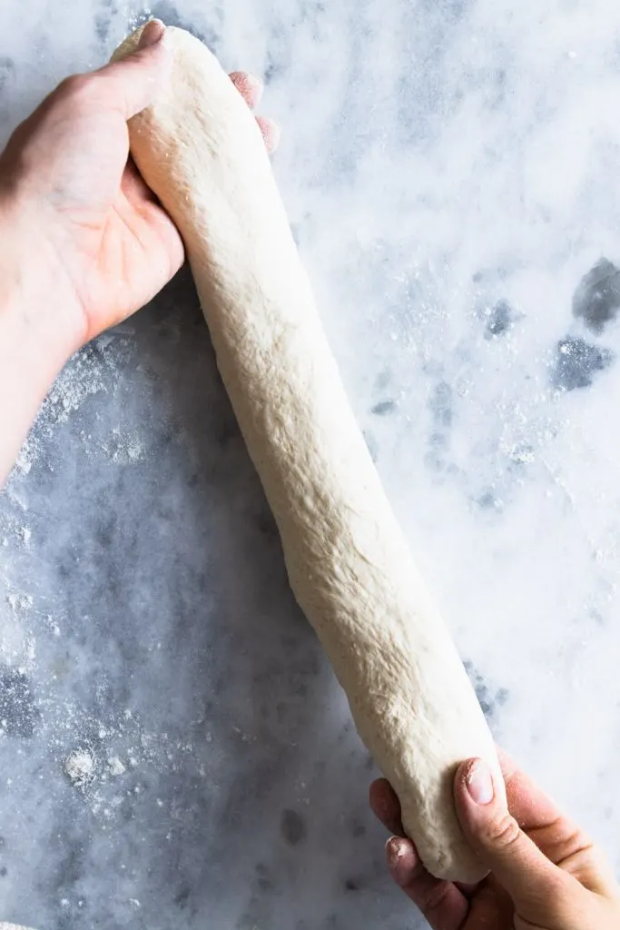 Step six for shaping baguettes: Gently pull and stretch the baguette to make it approximately 18" long.