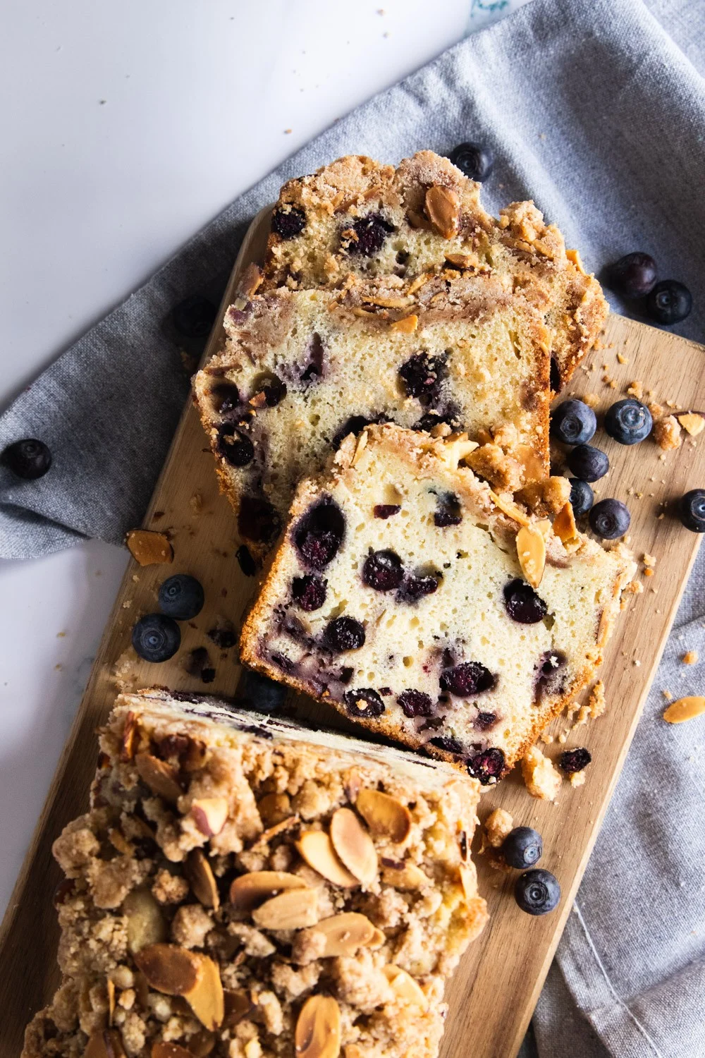 A sliced loaf of blueberry muffin bread with crumb topping