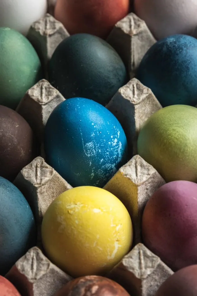A picture of easter eggs-green, yellow, blue, purple, orange, and brown--all dyed with food and food scraps.