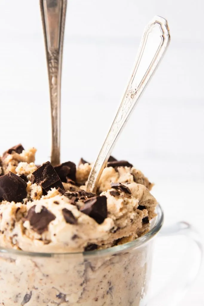 A bowl of edible cookie dough with two spoons to dig in.