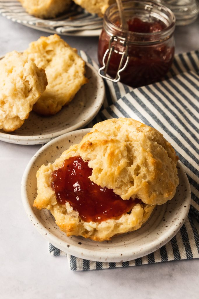 A buttermilk drop biscuit, served with butter and strawberry jam.