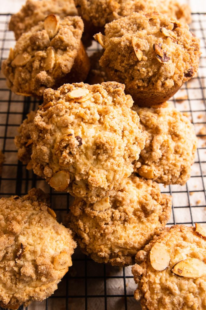 Coffee Cake Muffins with a crumb topping, piled on a cooling rack.