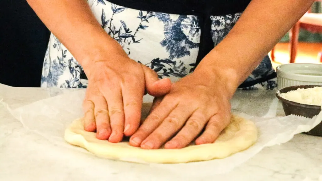 Use your hand to stretch the dough into a disc.