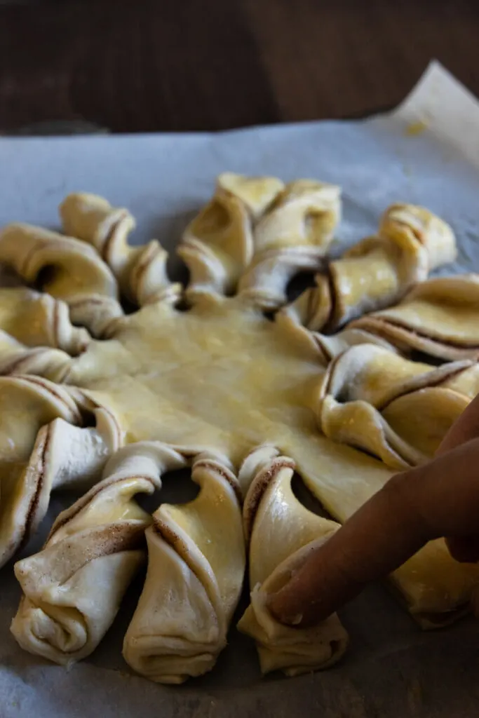 Twisting the pieces of the star, pressing the ends together to help them stick while baking.