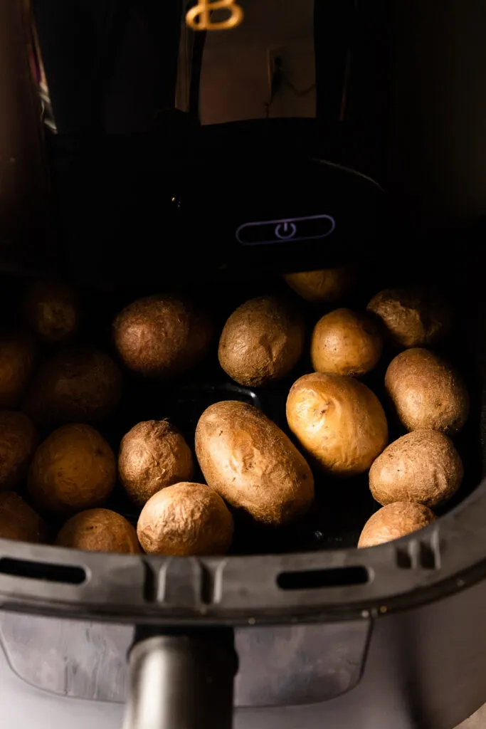 The potatoes, with slightly wrinkled skins after the first roasting time.