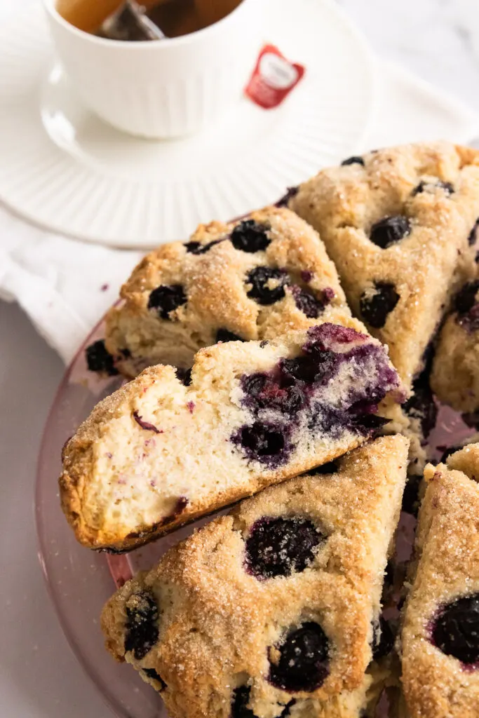 Sourdough blueberry scones, cut into a wedge and studded with blueberries and a fluffy, tender crumb.