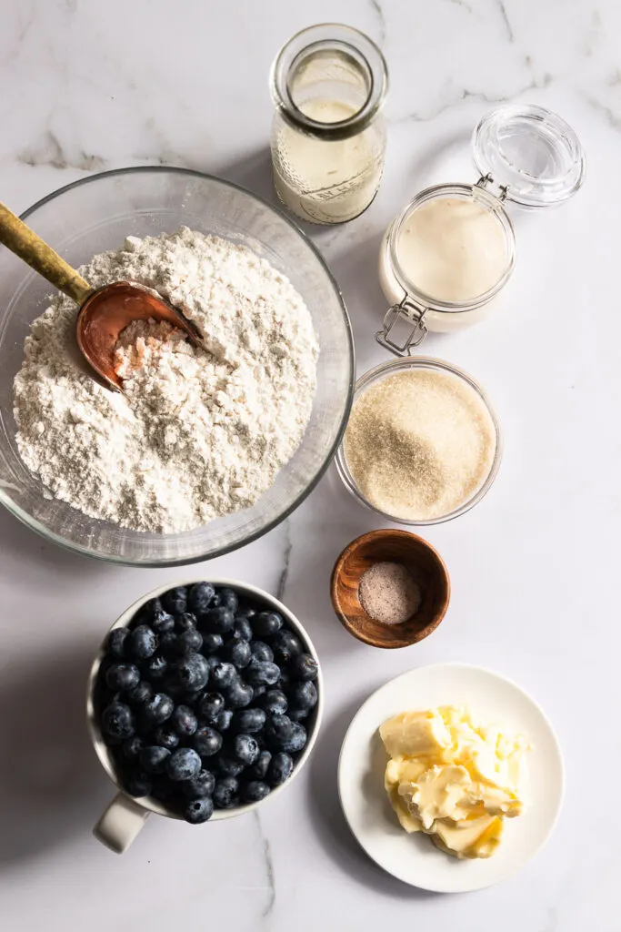 Sourdough Blueberry Scones ingredients: self-rising flour, butter, sugar, sourdough starter, cream and milk, salt, and blueberries.