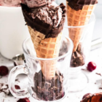 A double scoop of chocolate cherry ice cream in a chocolate dipped cone.