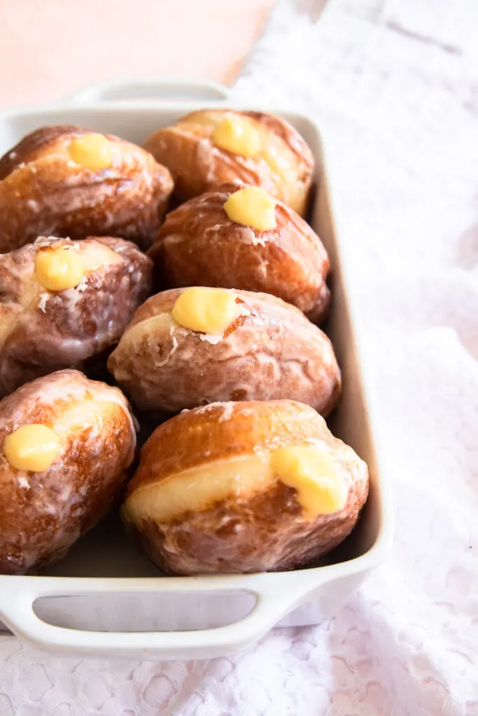 A glazed donut filled with passion fruit pastry cream.