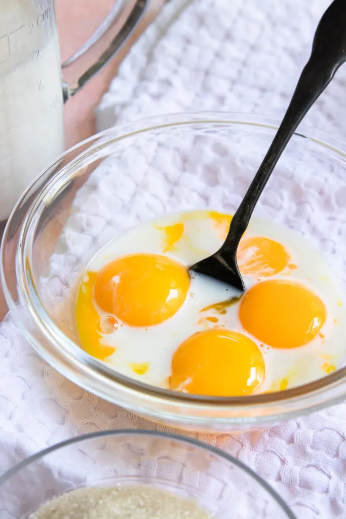 Whisk a bit of milk into the egg yolks.