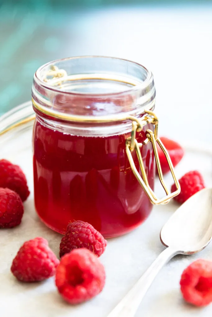 Raspberry simple syrup in a small jar.