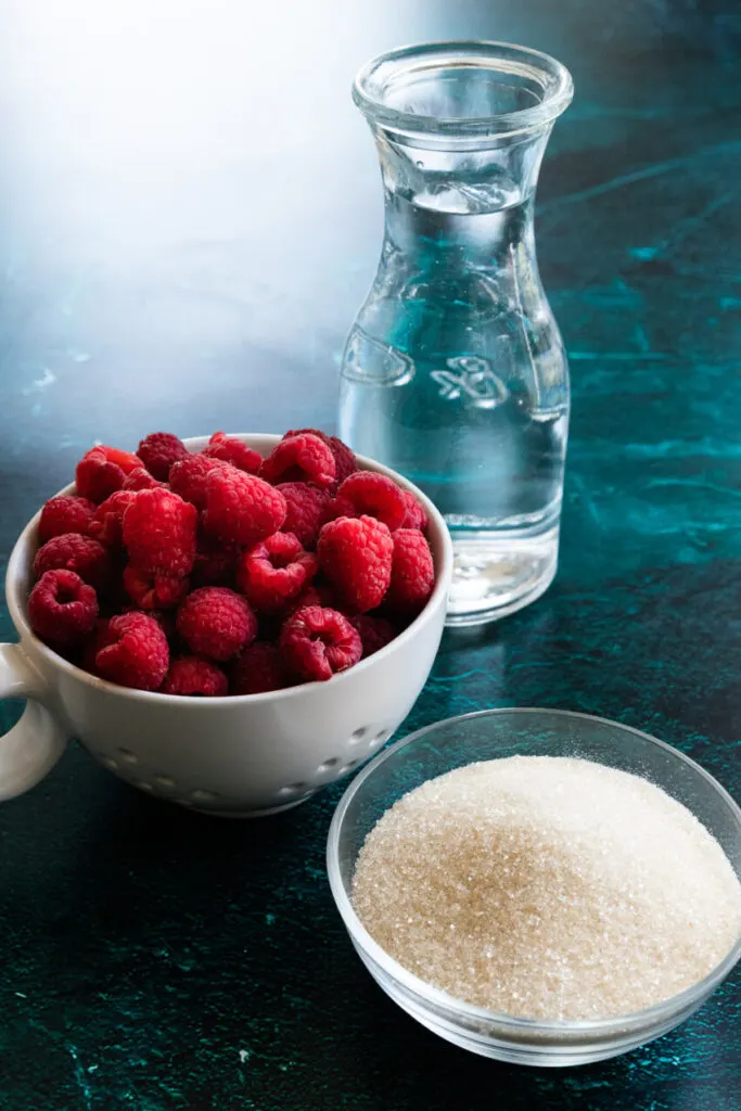 Raspberry simple syrup ingredients--water, sugar, and raspberries.