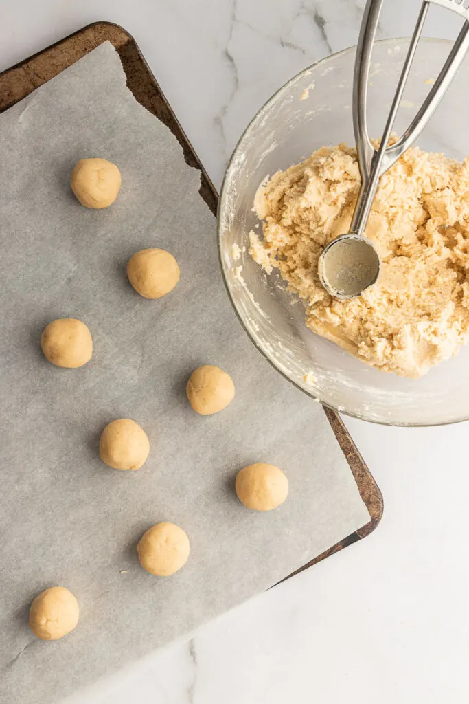 Scoop the cookie dough and then roll each scoop into round balls.