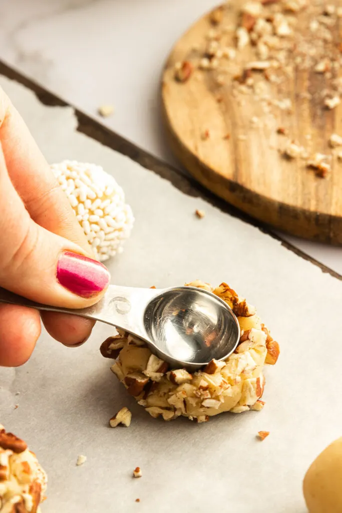 Press a rounded teaspoon into each ball of cookie dough.