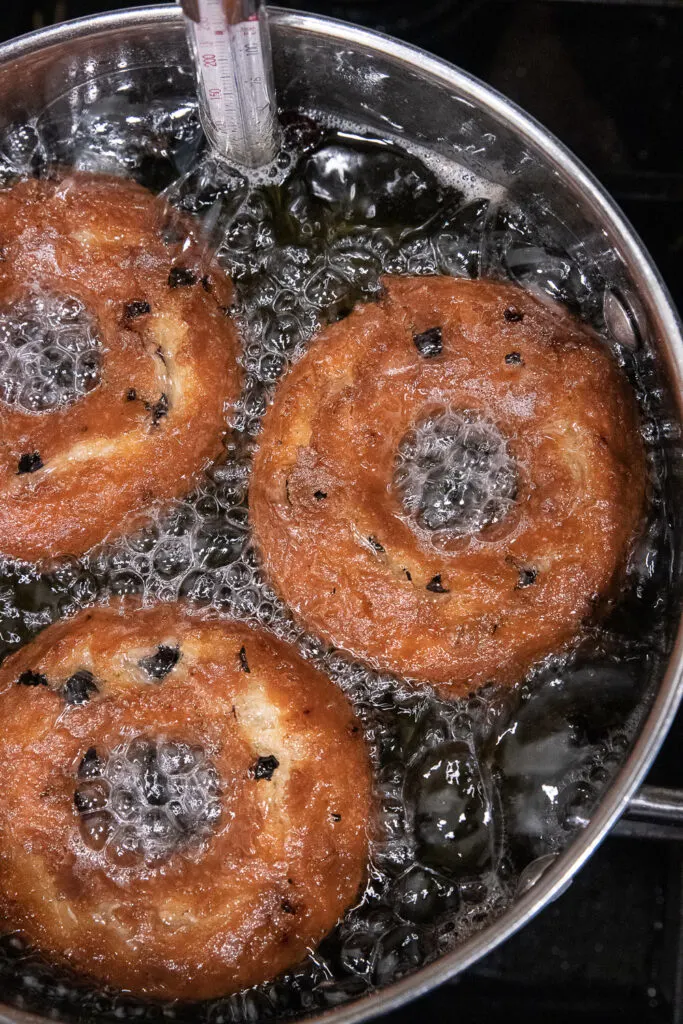 Frying the donuts in hot oil.
