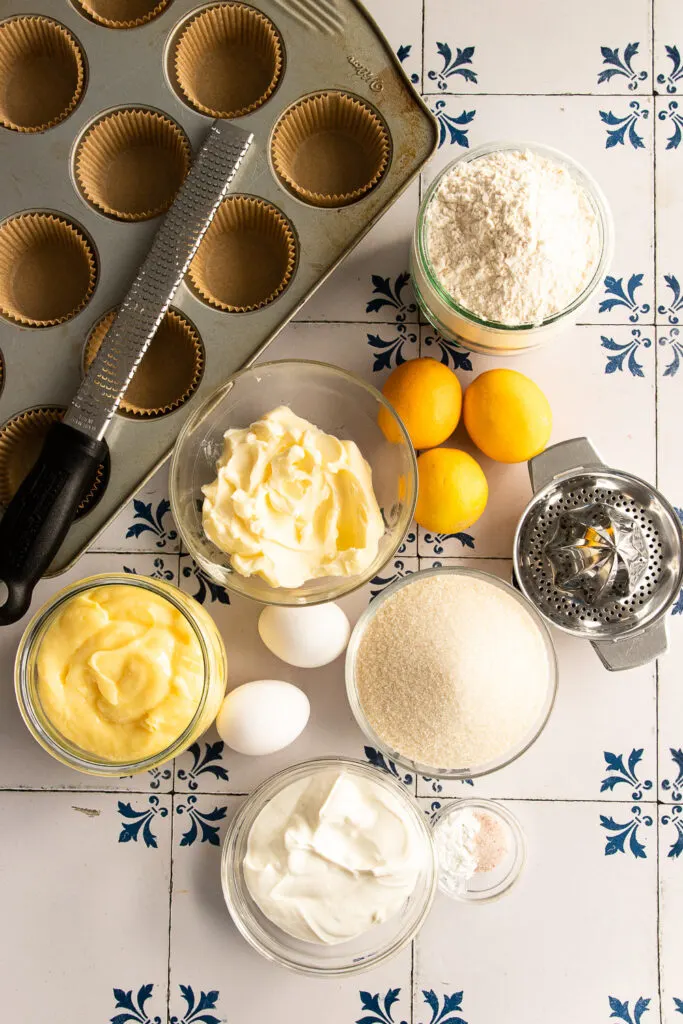 The ingredients for lemon curd muffins--butter, sugar, lemons, eggs, sour cream, baking powder, salt, flour, and lemon curd.