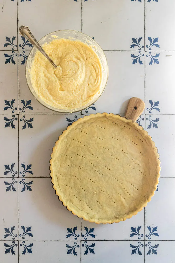 A parbaked crust and bowl of frangipane (almond cream) ready to add to it.