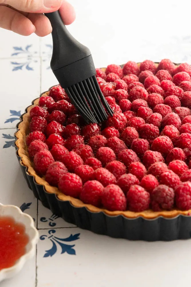 brushing jam over the top of the raspberries.