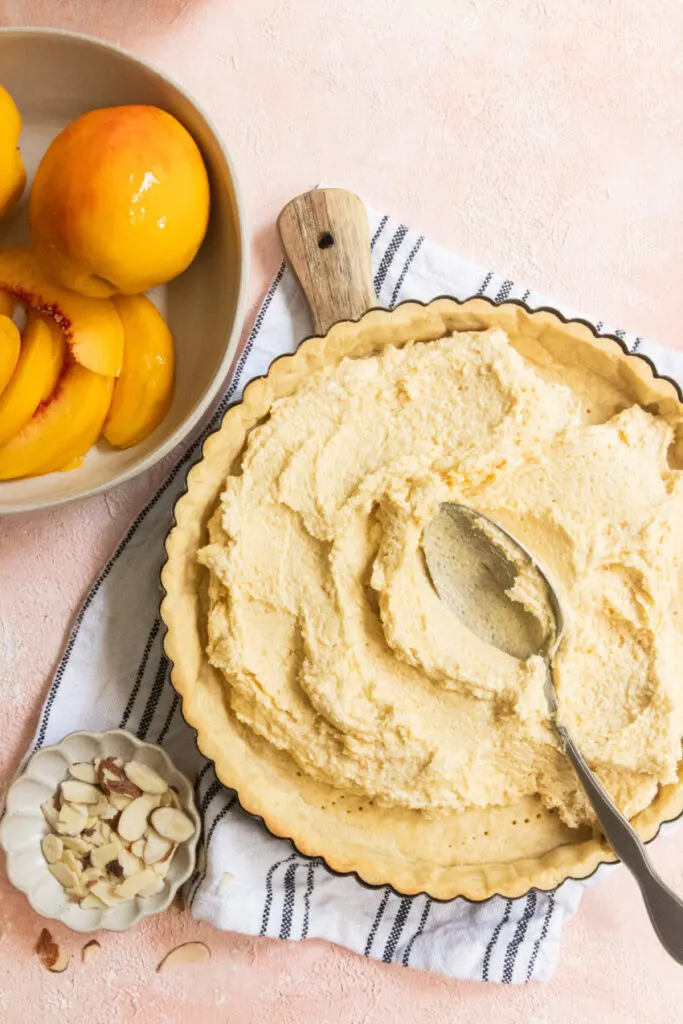 Spreading the almond cream in the bottom of the tart crust.