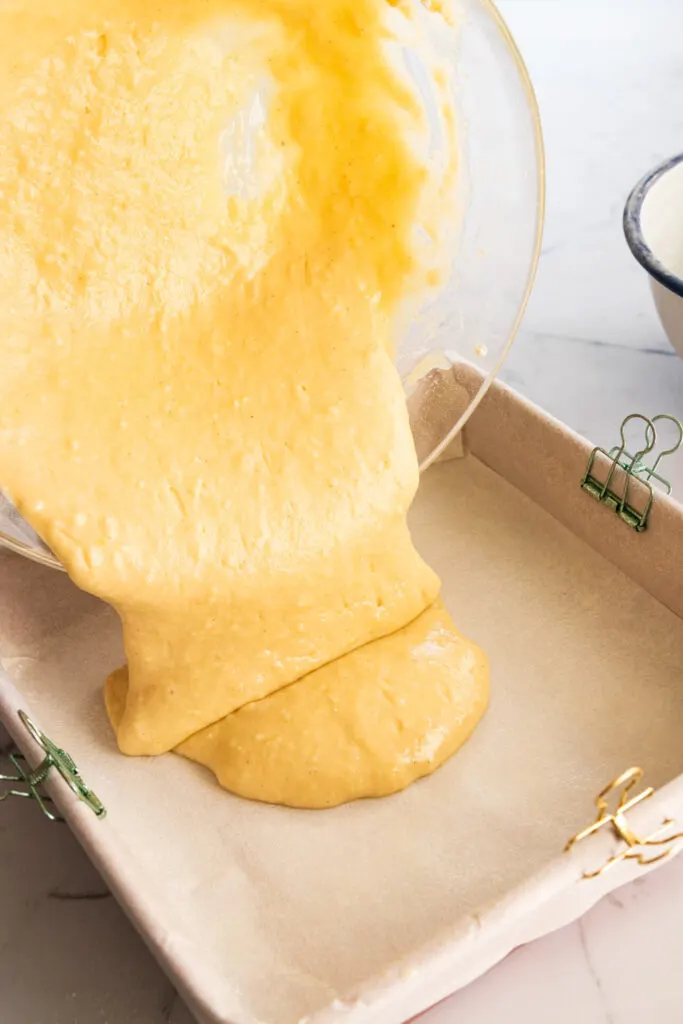 Pouring the batter into the parchment-lined cake pan.