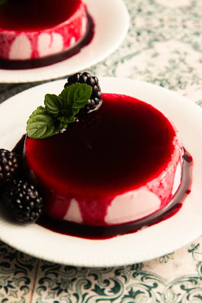 A plate with a blackberry panna cotta on it.