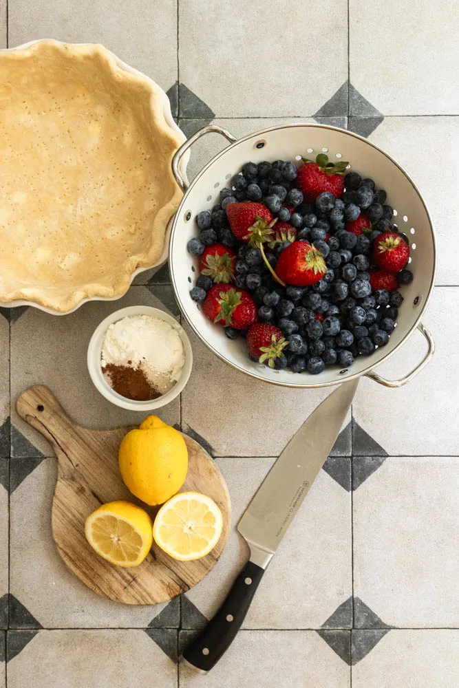 Ingredients for a strawberry blueberry pie--strawberries, blueberries, sugar, lemon juice,cornstarch, cinnamon, and salt.