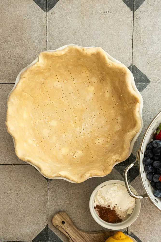 An all-butter pie crust, rolled, docked, and ready to fill.