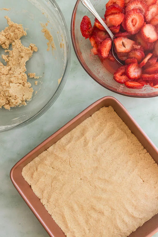A 9"x9" baking pan with 2/3 of the cookie dough pressed into the bottom.
